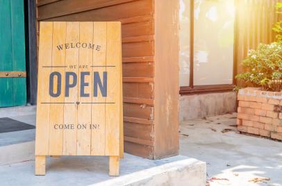 wooden welcome open sign in front of a business - grand opening concept