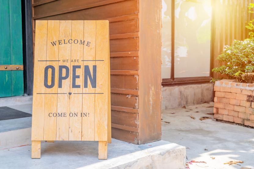 wooden welcome open sign in front of a business - grand opening concept