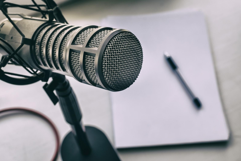 podcast equipment - microphone with pad of paper and pen