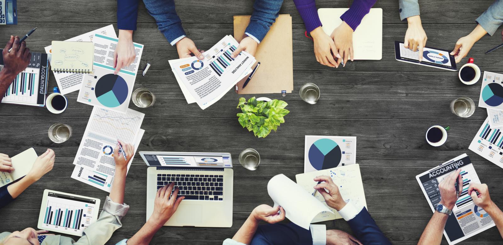 A table covered with documents, charts, and notes, illustrating the process of evaluating evidence and examining supporting information carefully.