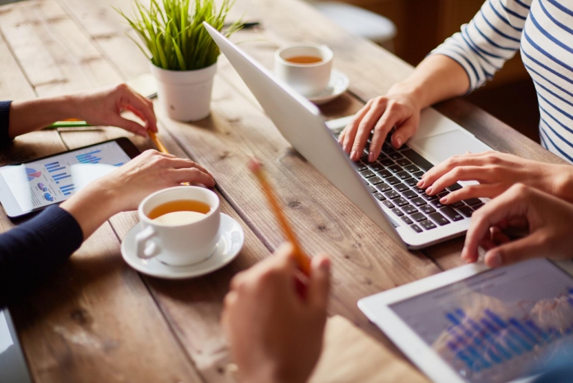 people using various devices at a table