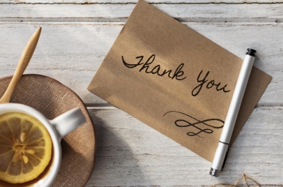 cup of lemon tea next to note with handwritten thank you