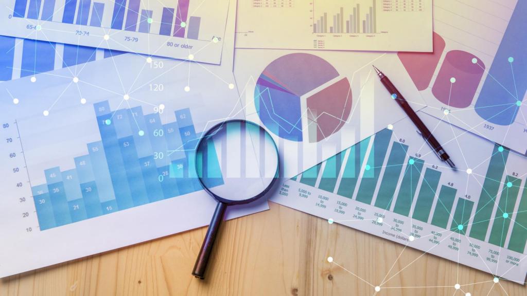 graphs and charts on a desk with a magnifying glass and a pen