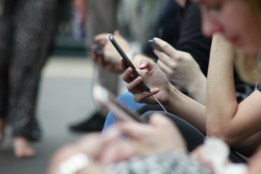 group of young people on their phones