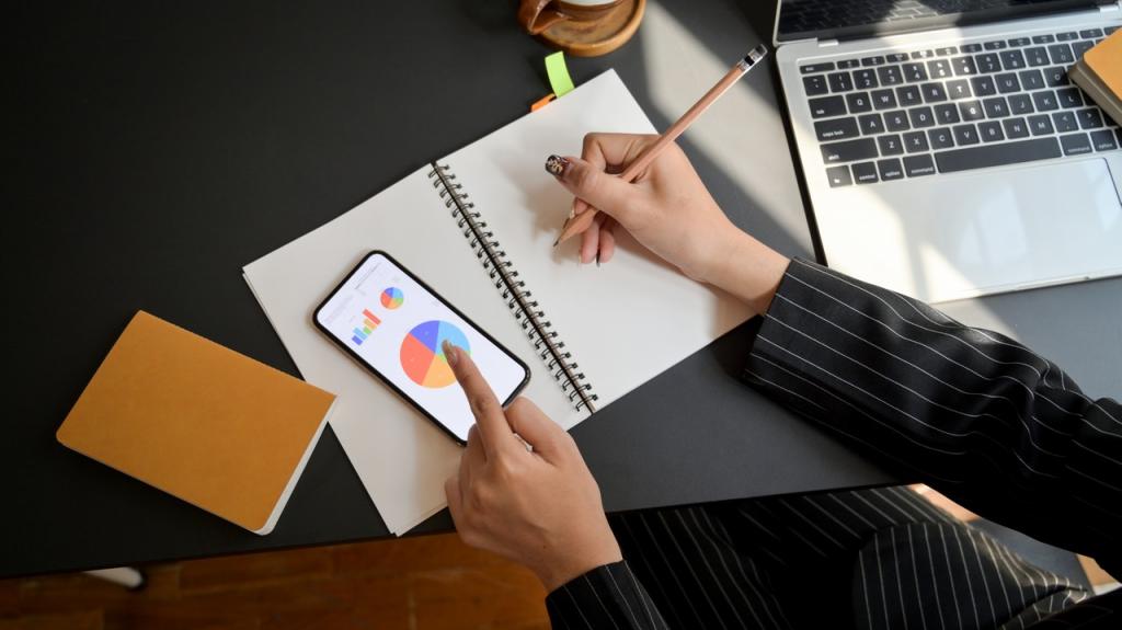 a woman writing in a notebook while using her phone and laptop