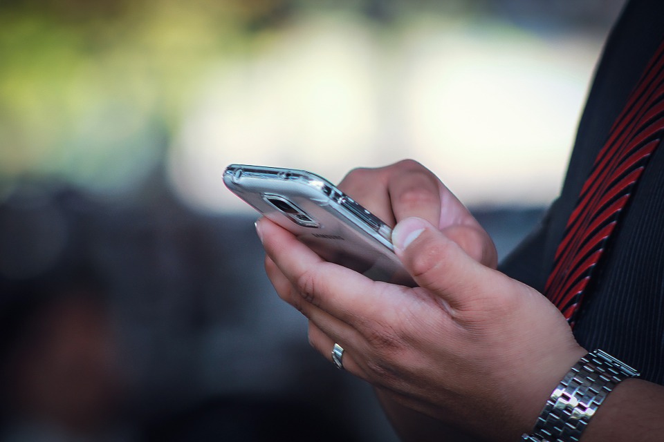 close-up of a person's hands holding a silver smartphone