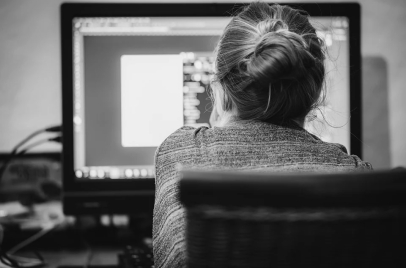 black and white image of a woman working on a computer