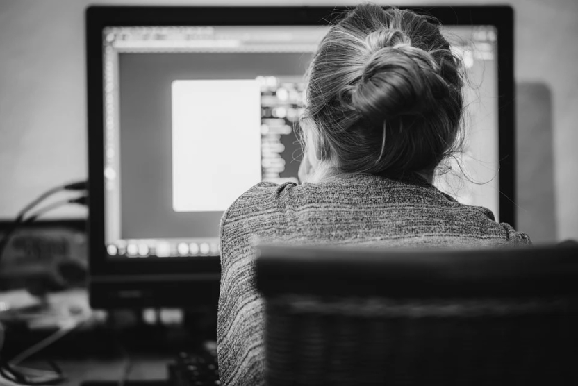 black and white image of a woman working on a computer