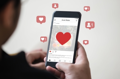 man holding a smartphone with hearts on it to represent instagram engagement