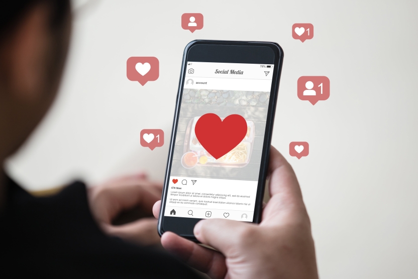 man holding a smartphone with hearts on it to represent instagram engagement