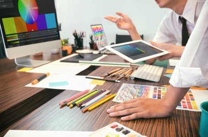 web design vs print design concept - artists brainstorming colors with screens and papers