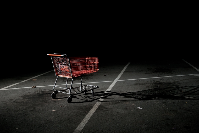 abandoned shopping cart in a dark parking lot