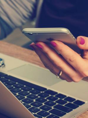 woman using a smartphone and laptop at the same time