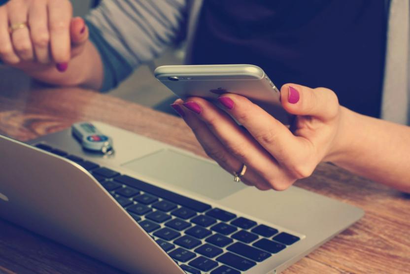 woman using a smartphone and laptop at the same time